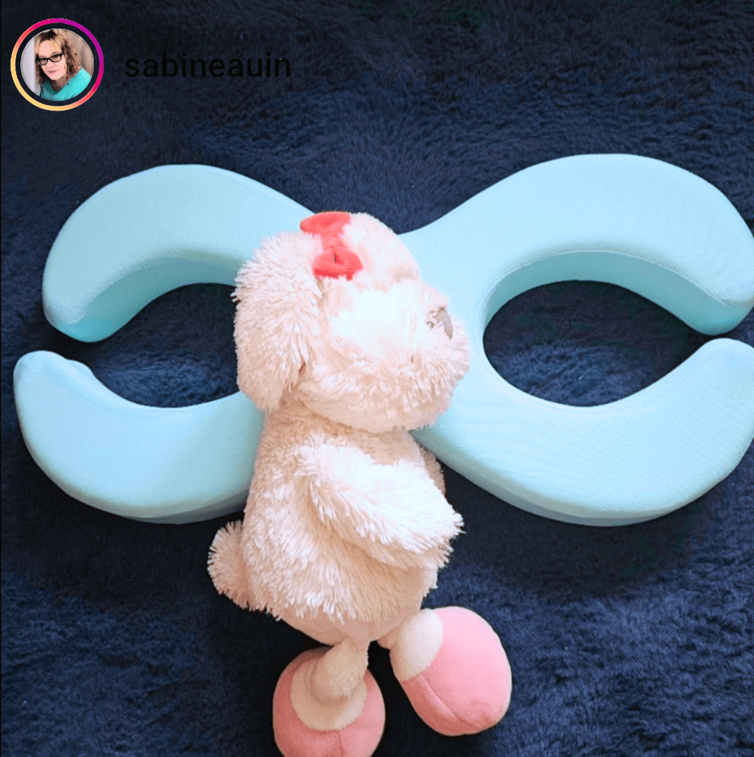 Schön im Schlaf Glow Kissen and a plush toy on a soft surface, showcasing comfort and relaxation.